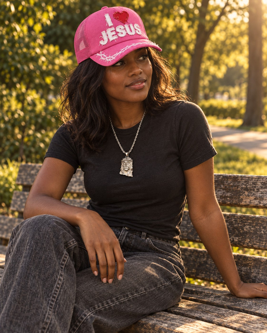 Model wearing pink Crowned Saints hat and silver Jesus Piece